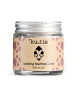 Natural soothing washing grains in powder form in a glass jar with an aluminium screw top silver lid.